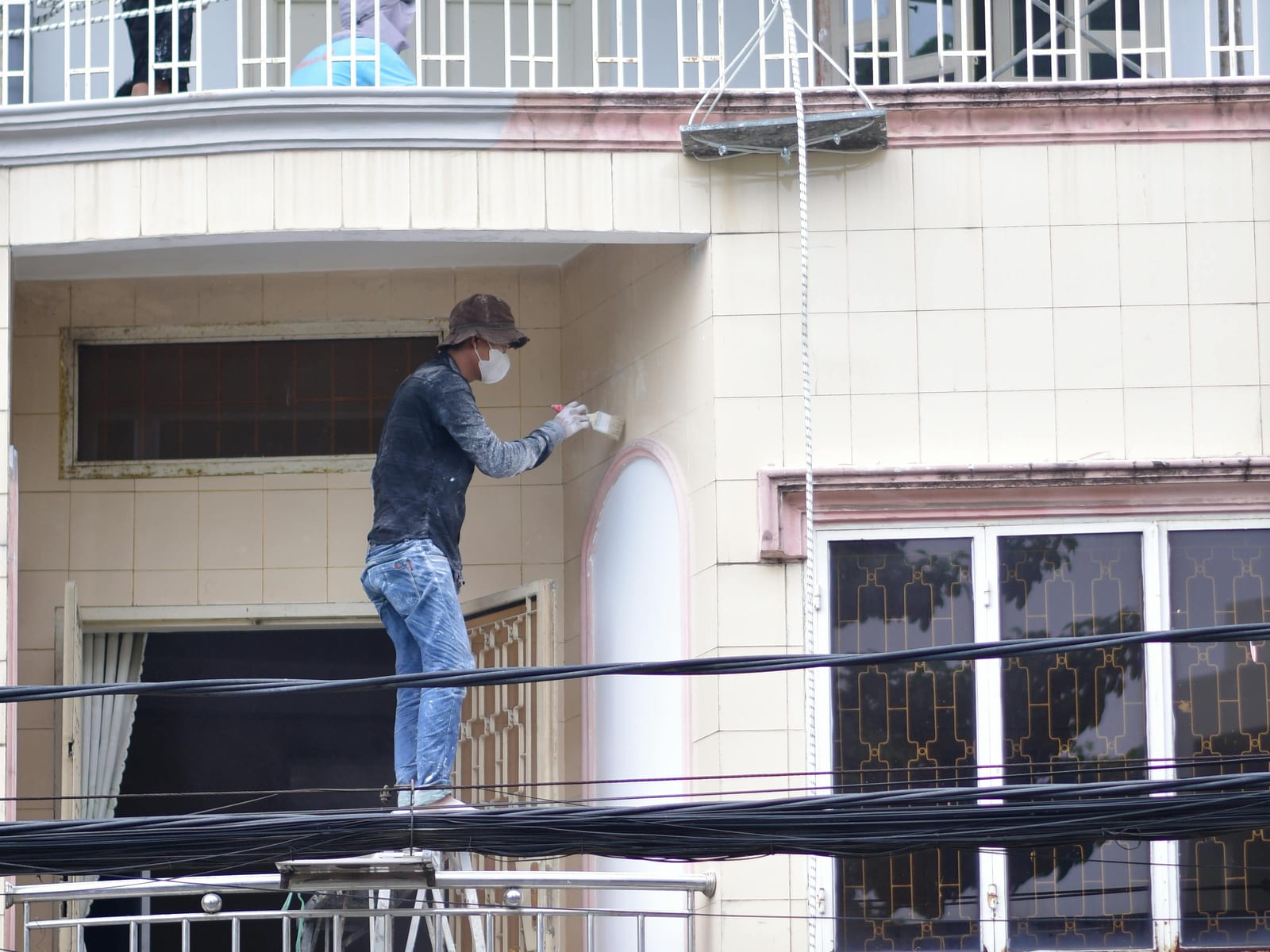 Workers painting a building exterior Workers painting a building exterior