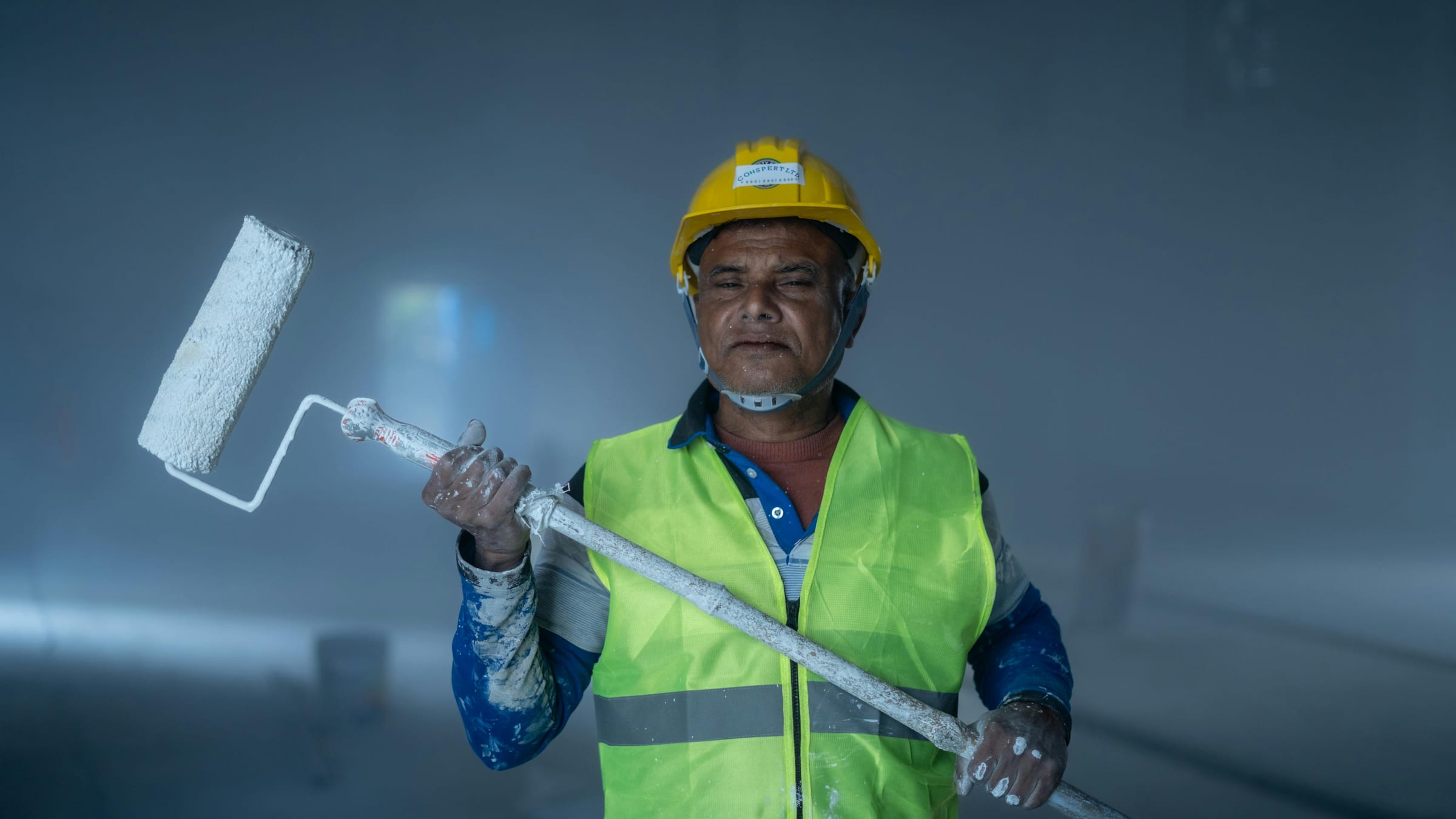 Commercial painter with roller inside a jobsite Commercial painter with roller inside a jobsite